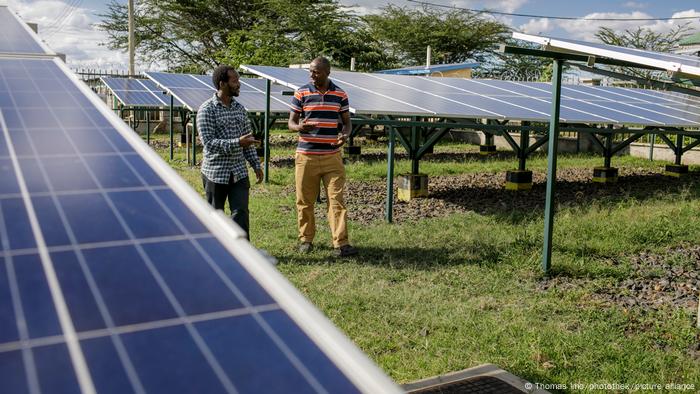 Dos trabajadores en medio de paneles solares en Kenia