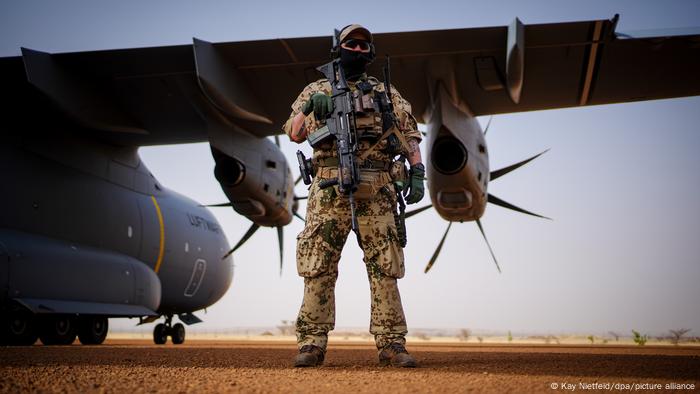 Member of German military stands by a plane