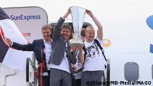 Frankfurts Trainer Oliver Glasner und Kapitän Sebastian Rode präsentieren beim Aussteigen aus dem Flugzeug den Pokal