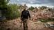 A Ukrainian territory defence soldier walks past the ruins of a building in Donbas A Ukrainian territory defence soldier walks past the ruins of a building in Donbas
