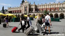 Spring In Krakow People with luggages walk the Main Square in Krakow, Poland on May 5, 2022. Krakow Poland PUBLICATIONxNOTxINxFRA Copyright: xJakubxPorzyckix originalFilename: porzycki-springin220505_np0RI.jpg 