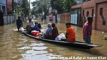 Sylhet, Bangladesh: People going on a boat on a submerged road in the Uposhahar Residential area of Sylhet, Bangladesh. As the flood worsens in Sylhet city, many people of Uposhahar Residential areas leave their homes for a safe place.