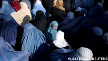FILE PHOTO: A girl sits in front of a bakery in the crowd with Afghan women waiting to receive bread in Kabul, Afghanistan, January 31, 2022. REUTERS/Ali Khara/File Photo