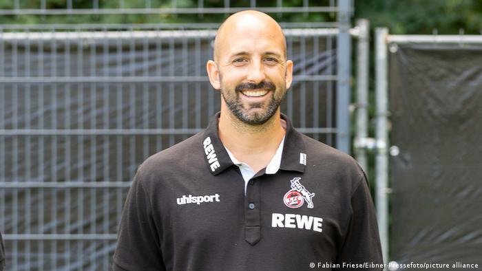 Moritz Anderten, a bald man with a beard, wearing a black polo shirt, smiling