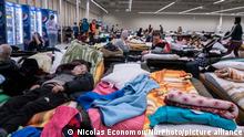 Temporary sleeping area with camp beds and mattresses for people at the former shopping center. The Temporary Humanitarian Aid Centre in Przemysl, a town 10km from Ukraine and the Medyka Shehyni border crossing. The Humanitarian center was a former shopping mall that has been transformed by volunteers, charities, NGOs, the local authorities and the Polish armed forces to the largest aid center in the region. Ukrainian refugees can find shelter, sleep, medical aid, food, register and arrange their transportation further for relocation to Europe or Poland. According to UN - UNHCR more than 3.3 million refugees left the country as United Nations announced and showed the data on a map and almost 6.5 million Ukrainians have been internally displcaed. Przemysl, Poland on March 18, 2022 (Photo by Nicolas Economou/NurPhoto)