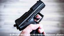 Ein Mann hält eine Pistole in seiner Hand, zielen und schießen mit einer Waffe Symbolbild