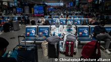 China Shanghai | Menschen in Schuzanzügen am Bahnhof Hongqiao