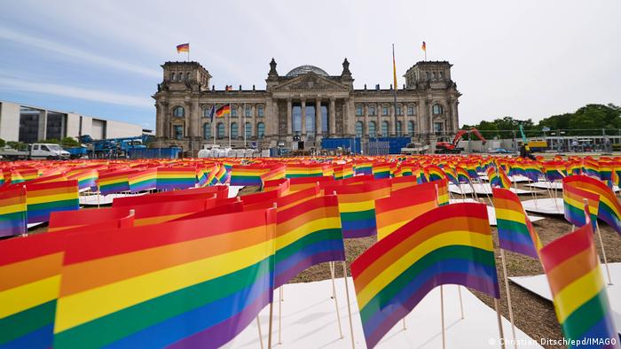 Zastavice duginih boja ispred nemačkog parlamenta u Berlinu. Ima ih tačno 1.051 – za isto toliko registrovanih zločina nad kvir-osobama. Inicijativa „Osnovni zakon za sve“ (GFA) na taj način pokušava da utiče na poslanike da izmenama Osnovnog zakona (ustava) izričito zaštite polni i rodni identitet.