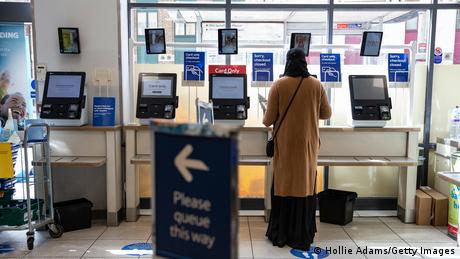 A woman uses a self-checkout at a Tesco on April 13, 2020 in London, United Kingdom