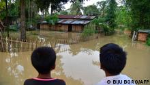 Flood-affected children look at their partially submerged house after heavy rains in Morigaon district of India's Assam state on May 23, 2022. - Floods are a regular menace to millions of people in low-lying Bangladesh and neighbouring northeast India, but many experts say that climate change is increasing the frequency, ferocity and unpredictability. (Photo by Biju BORO / AFP)
