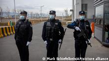FILE - Police officers stand at the outer entrance of the Urumqi No. 3 Detention Center in Dabancheng in western China's Xinjiang Uyghur Autonomous Region on April 23, 2021. State officials took AP journalists on a tour of a training center turned detention site in Dabancheng sprawling over 220 acres and estimated to hold at least 10,000 prisoners - making it by far the largest detention center in China and among the largest on the planet. (AP Photo/Mark Schiefelbein, File)
