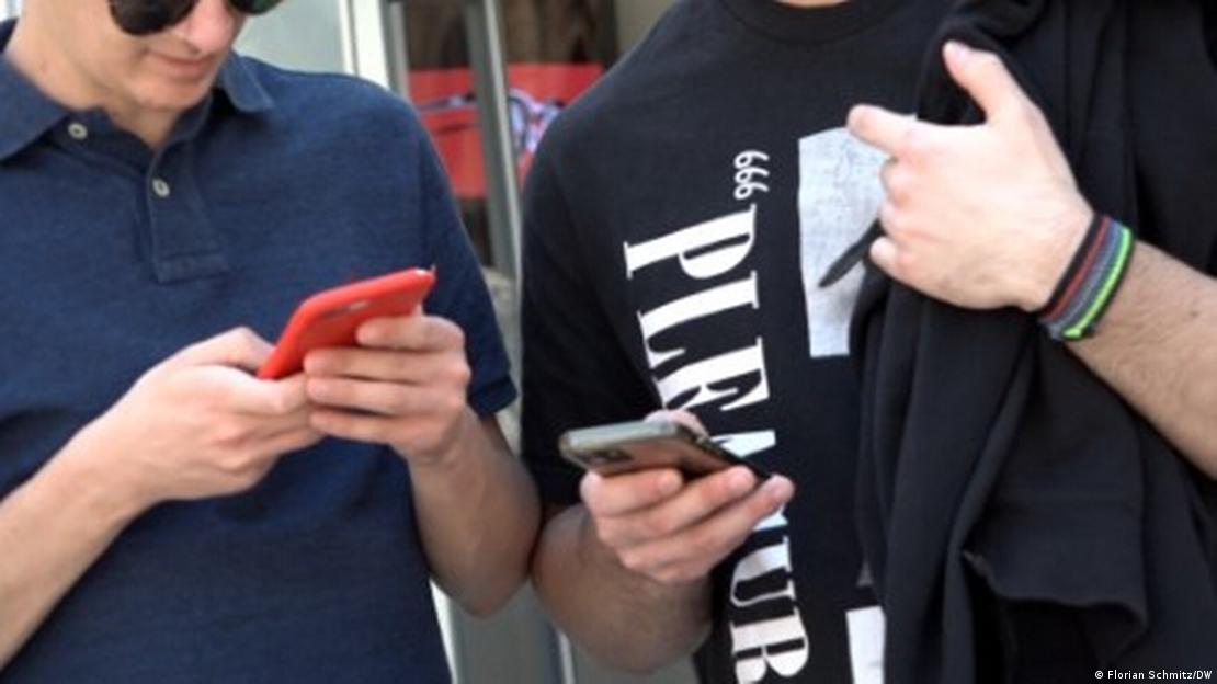 Δυο νεαροί κρατούν ένα κινητό στα χέρια 