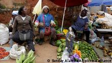 In this photo taken Friday, Oct. 5. 2018, women sell fruits in a market in Yaounde, Cameroon. Africa's oldest leader is expected to win Sunday's election despite Anglophone separatists threatening to disrupt it. (AP Photo/Sunday Alamba)