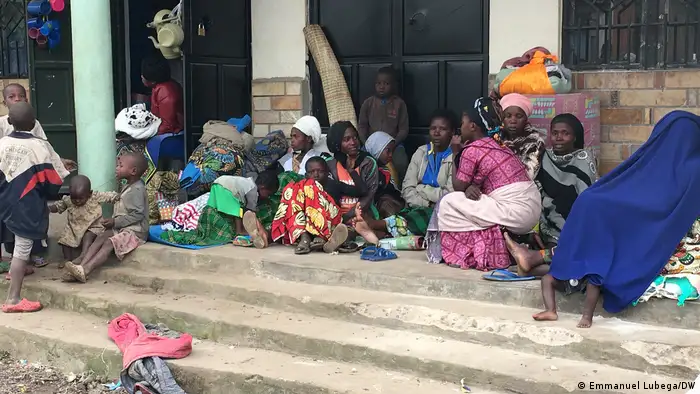 A group of displaced people sitting on some steps in Bunagana, Uganda