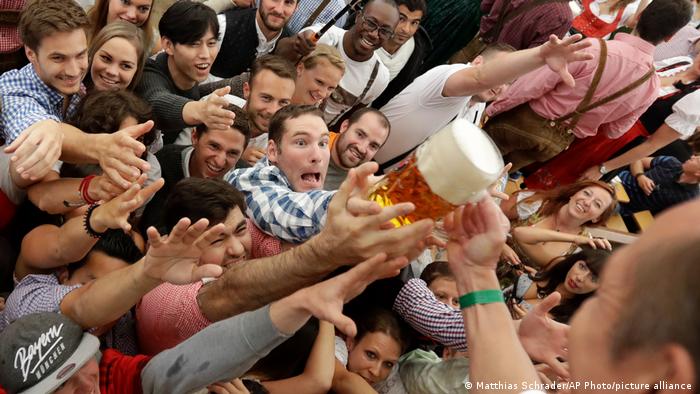 Münchner Oktoberfest: Hände greifen nach einer Maß Bier