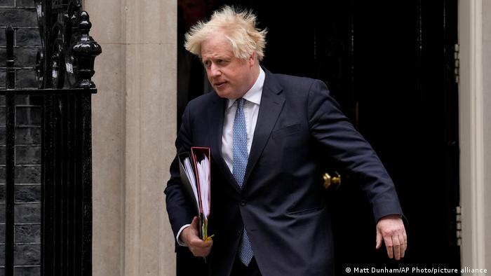 Boris Johnson with binders under his arm and wind-blown hair