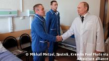 Russian President Vladimir Putin, right, shakes hands with Warrant officer Yuzbeg Kazitov, left, and Sgt. Ivan Petruk, second left, at the Central Military Clinical Hospital in Moscow, Russia, Wednesday, May 25, 2022. Kazitov and Petruk were wounded during Russia's military operation in Ukraine. (Mikhail Metzel, Sputnik, Kremlin Pool Photo via AP)