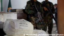 Police officers stand guard next to a bags of seized cocaine during a presentation at a police base in Lima, Peru, Wednesday, June 14, 2017. According to police more of two tons of cocaine were seized over the last weeks in several operations nationwide. (AP Photo/Martin Mejia)