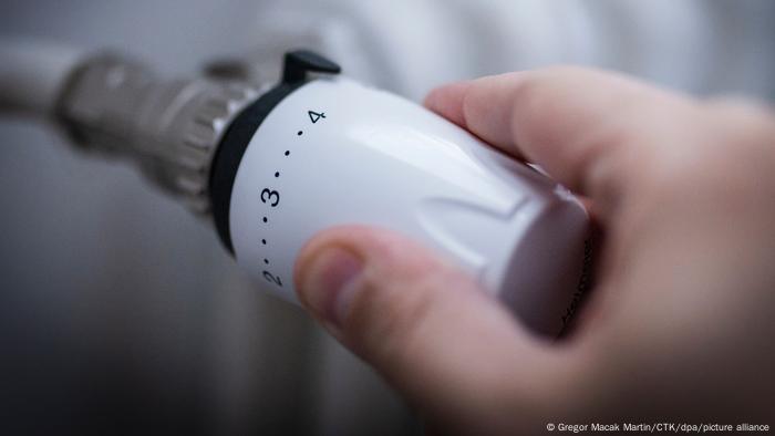 Person's fingers turning a heating knob