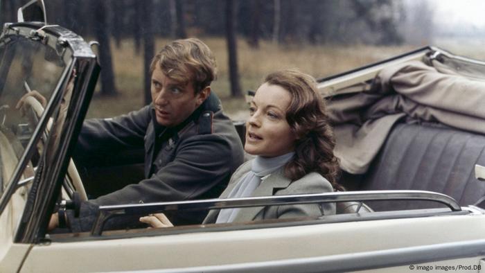 Romy Schneider sitzt mit ihrem Filmpartner im Cabrio. 