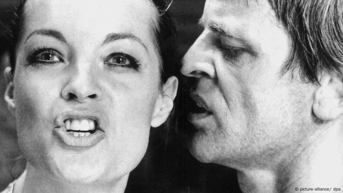 Romy Schneider und Klaus Kinski in Nachtblende. Sie blickt nach vor, er steht neben ihr und hat sein Gesicht seitlich nah an ihrem. 