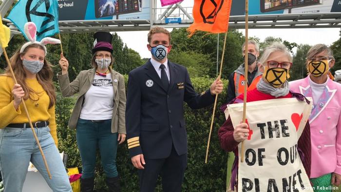 Todd Smith in his pilot's uniform standing with fellow Extinction Rebellion protesters