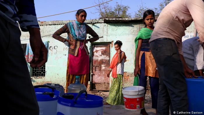 Women collect water during a heatwave in Delhi
