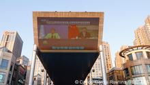 Chinese President Xi Jinping and United Nations High Commissioner for Human Rights Michelle Bachelet are seen on a giant screen broadcasting news footage of their virtual meeting at a shopping complex, as a helicopter flies over in Beijing, China May 25, 2022. REUTERS/Carlos Garcia Rawlins