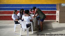A woman signs in to vote at polling station during the first round of the presidential election in Suarez, Colombia May 29, 2022. REUTERS/Luisa Gonzalez