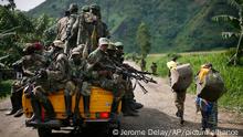 FILE - In this Nov. 30, 2012 file photo, M23 rebels withdraw from the Masisi and Sake areas in eastern Congo. A Congolese rebel group whose fighters retreated into Uganda after being hammered by U.N.-backed Congolese government forces ¿can still regroup,¿ a Ugandan government spokesman said Tuesday, Nov. 12, 2013. The warning came after Congolese government officials delayed signing a peace accord with the insurgents. (AP Photo/Jerome Delay, File)