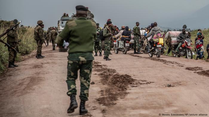 People walk on the road near Kibumba, north of Goma, Democratic Republic of Congo, as they flee fighting between Congolese forces and M23 rebels in North Kivu, Tuesday May 24, 2022.