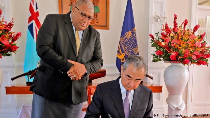 王毅到访斐济，在苏瓦总统府留言簿上留言。站在他身后的是斐济总统卡托尼韦雷。