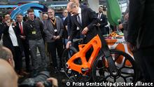 Bundeskanzler Olaf Scholz (SPD, r) steht bei seinem Eröffnungsrundgang auf der Hannover Messe 2022 am Stand der Firma Igus Bike. Die Firma baut Räder aus recyceltem Kunststoff. In diesem Jahr ist Portugal das Partnerland der Messe. +++ dpa-Bildfunk +++