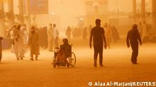 People are pictured during a sandstorm in Najaf, Iraq, May 23, 2022. REUTERS/Alaa Al-Marjani