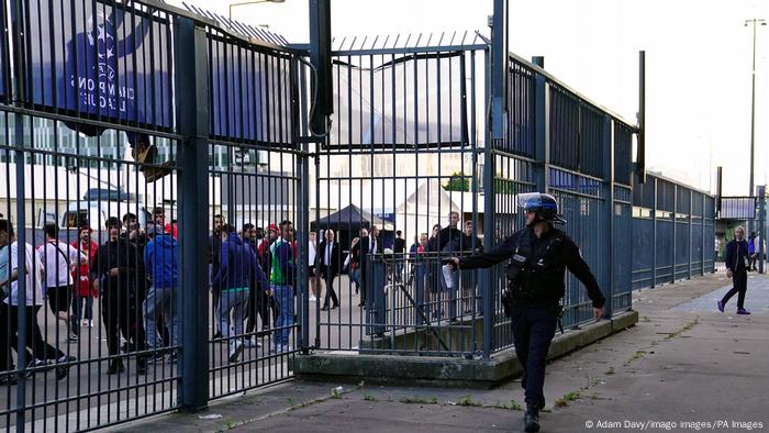 A French police officer uses pepper spray on fans at the Champions League final in Paris on Saturday 28 May 2022. 