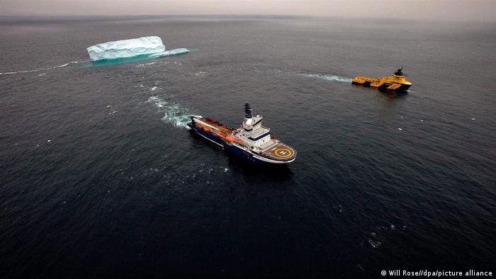 Transporte de un trozo de iceberg por un barco de una petrolera.