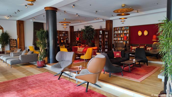 A living room with chairs and bookshelves along the wall.