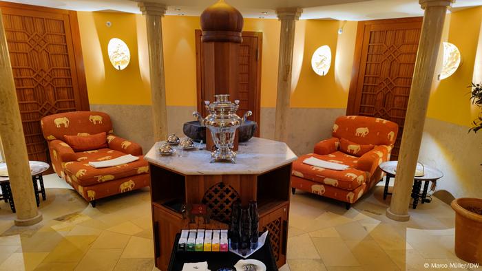 A tea table in an ornate room with two lounge chairs.