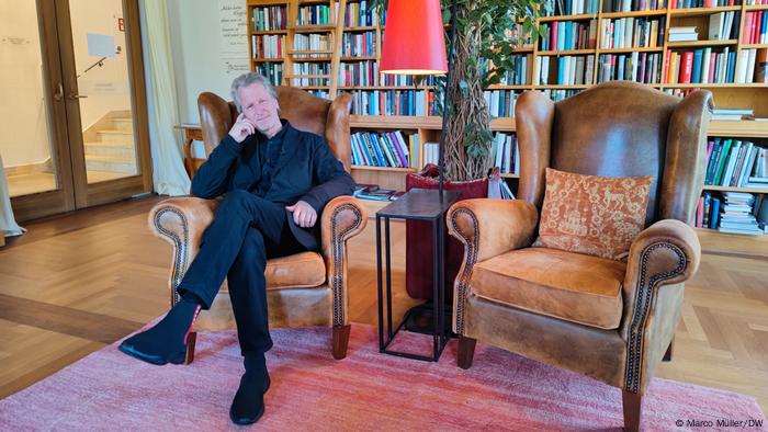 Castle owner Dietmar Müller-Elmau sits in a chair in the library at Schloss Elmau