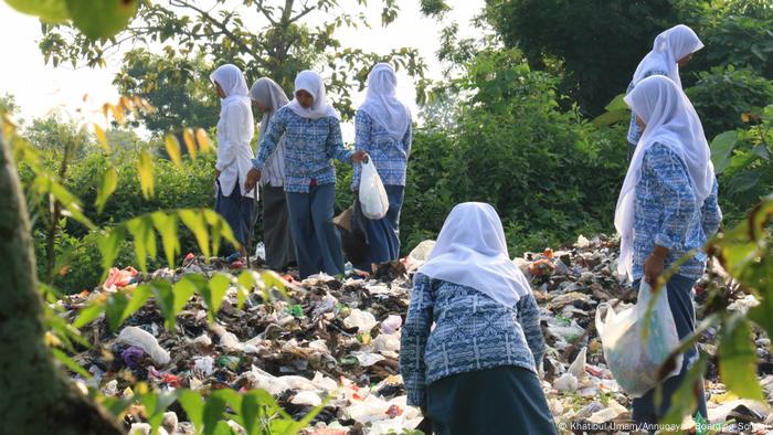 Para siswi Muslim mengumpulkan sampah untuk melindungi lingkungan di pulau Madurai di Indonesia