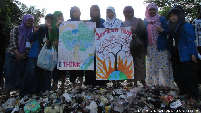 Murid-murid Pesantren Anugaya membawa plakat yang mempromosikan upaya perlindungan lingkungan