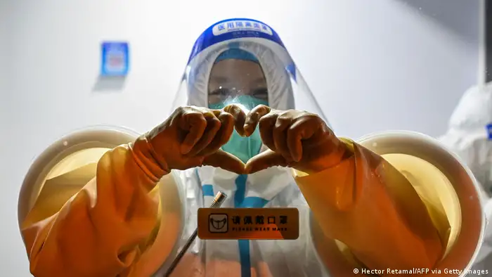 上海静安区的一位防疫工作人员用手比心