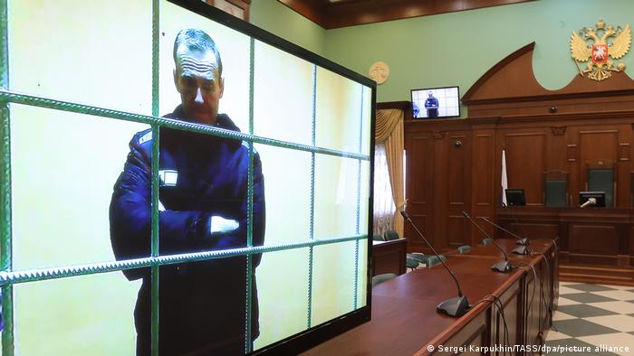 Навальный на экране монитора в суде