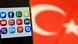 A symbolic image showing a phone with the logos of several popular social media and communication applications visible on its display screen, overlaid against the backdrop of a Turkish flag. A symbolic image showing a phone with the logos of several popular social media and communication applications visible on its display screen, overlaid against the backdrop of a Turkish flag.