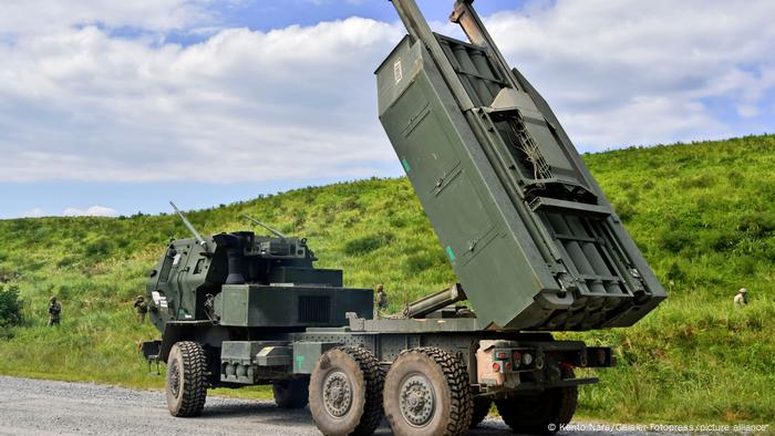 A truck missile launcher on a road adjusts the launcher device toward the sky