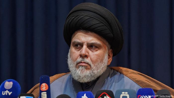 Muqtada al-Sadr, Iraqi militia leader and Shiite Muslim cleric, sits behind microphones