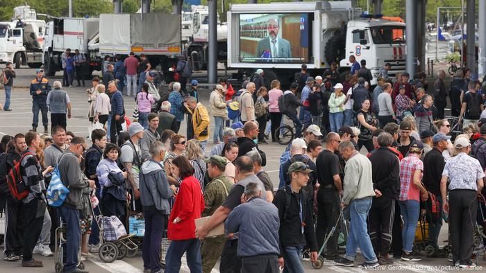 A truck with a video screen broadcasting Russian TV at the point of distribution of humanitarian aid in Mariupol