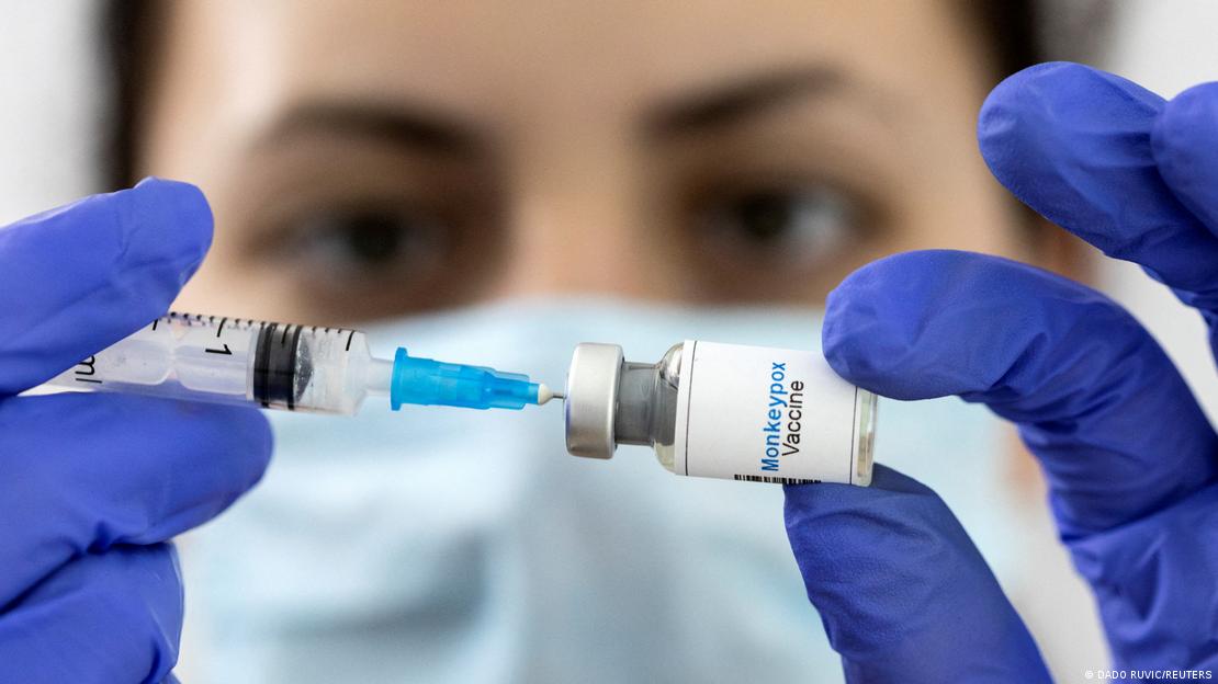 Uma laboratorista segura uma seringa e um frasco que contém o líquido da vacina contra a varíola dos macacos.