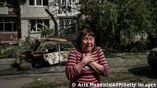 TOPSHOT - A woman reacts outside a damaged appartment building after a strike in the city of Slovyansk at the eastern Ukrainian region of Donbas on May 31, 2022, amid Russian invasion of Ukraine. (Photo by ARIS MESSINIS / AFP) (Photo by ARIS MESSINIS/AFP via Getty Images)