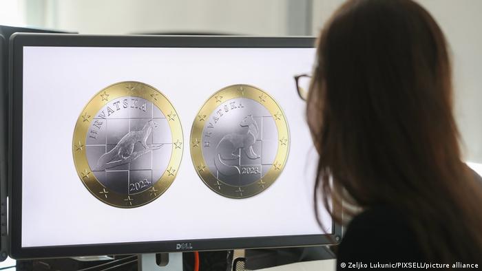 A woman looks at a version of the new one-euro coin in Croatia
